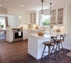 a kitchen with white cabinets and wooden floors