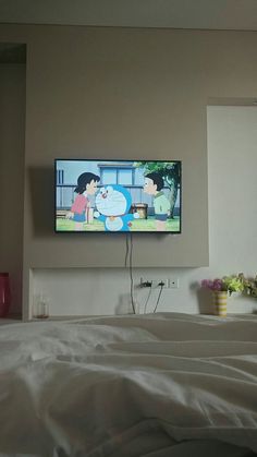 a flat screen tv mounted on the wall above a bed