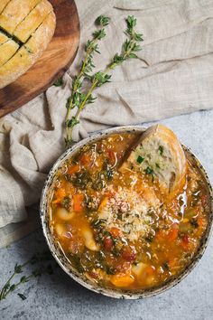 a bowl of soup with bread and parsley on the side