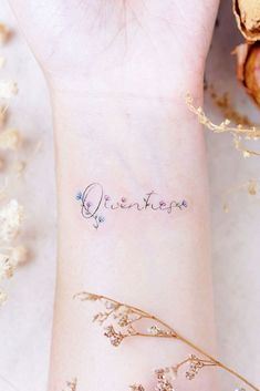 a small wrist tattoo with the word adventure written on it