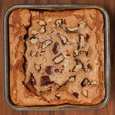 a chocolate chip cookie in a pan on a wooden table