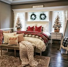 a bedroom decorated for christmas with wreaths on the window sill and plaid bedding