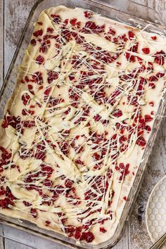 an uncooked dessert with white icing and cranberry toppings on top