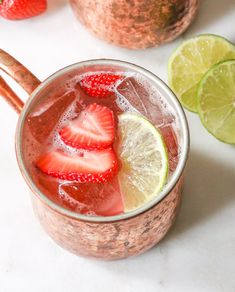 a drink with strawberries and limes in it