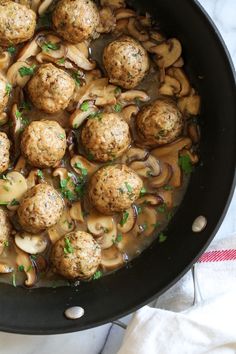 meatballs and mushrooms are cooking in a skillet on the stove top, ready to be eaten