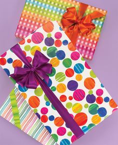 two colorful gift bags with ribbons on them