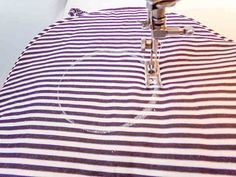 the sewing machine is working on the striped fabric