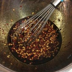 a metal bowl filled with food and whisk