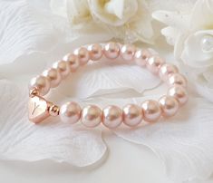 This personalized flower girl bracelet is made with blush pink color little glass pearls (8 mm) and rose gold plated hand stamped heart charm. This stretch pearl bracelet is perfect gift for your flower girls, jr bridesmaids or bridesmaids. Please visit my store to see the other wedding jewelry https://www.etsy.com/shop/asteriasbridal Rose Gold Heart Charm Bracelet For Wedding, Rose Gold Bracelets With Pearl Charm For Wedding, Rose Gold Wedding Bracelets With Pearl Charm, Adjustable Rose Gold Heart Bracelet For Wedding, Personalized Pink Charm Bracelet For Wedding, Personalized Rose Gold Charm Bracelet For Wedding, Elegant Personalized Pink Heart Bracelet, Personalized Rose Gold Name Bracelet For Wedding, Gold Flower Girl