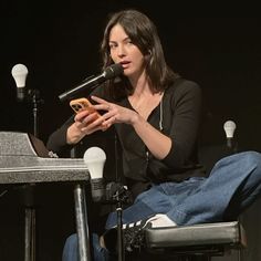 a woman sitting in front of a microphone