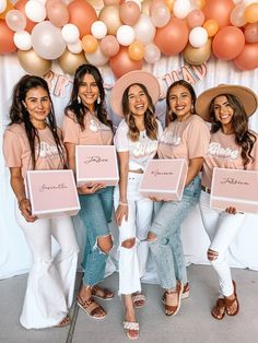 a group of women standing next to each other in front of balloons and holding signs