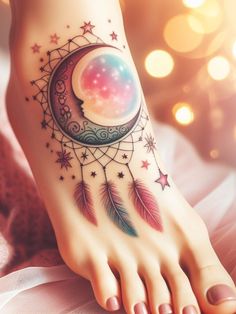 a woman's foot with a moon and stars tattoo on it