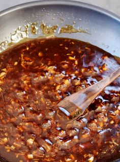 a wooden spoon in a pot filled with food