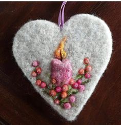 a heart shaped ornament with a lit candle