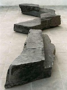 two large rocks sitting on top of a cement floor