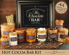 the hot cocoa bar kit is displayed in front of a framed sign and other items