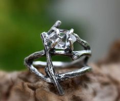 a silver ring sitting on top of a piece of wood