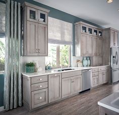 a kitchen with gray cabinets and white counter tops