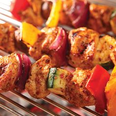 several skewers of meat and vegetables on a grill