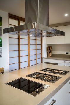 a stove top oven sitting inside of a kitchen next to a wall mounted range hood