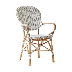 a wicker chair with black and white polka dots on it's armrests