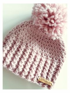 a crocheted hat with a pink pom - pom