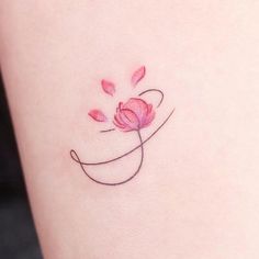 a small pink flower on the side of a woman's thigh with an arrow