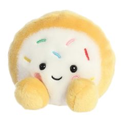 a yellow and white stuffed animal with sprinkles on it's face