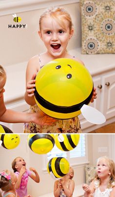 two girls are playing with balloons in the kitchen and one girl is holding a smiley face balloon