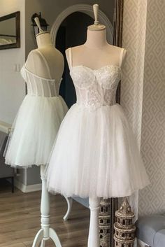 two mannequins are on display in front of dresses