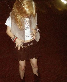 a woman with long hair is standing on a skateboard