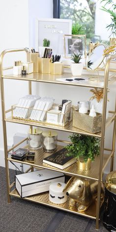 a gold shelf filled with books and other items