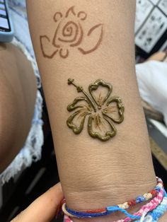 a woman's arm with a tattoo on it that has a flower drawn on it