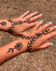 two hands that have tattoos on them and flowers on the wrist, both with different designs