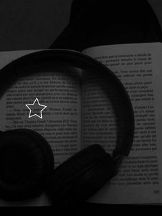 headphones on top of an open book with a white star in the middle of it