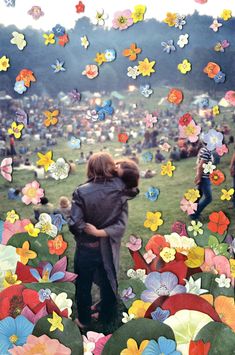 two people hugging each other in front of a field full of flowers