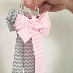 a person is holding three different colored hair ties in one hand and two silver rings in the other