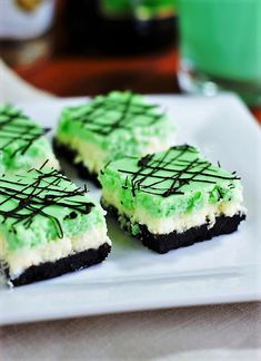 three pieces of cake on a plate with green frosting and chocolate sprinkles