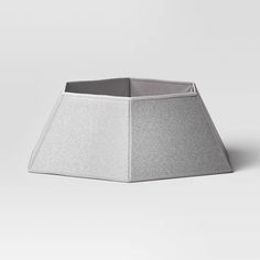 a white lamp shade sitting on top of a gray table cloth covered flooring area