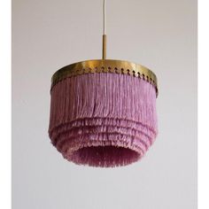 a pink chandelier hanging from a ceiling with gold trim and fringes on it