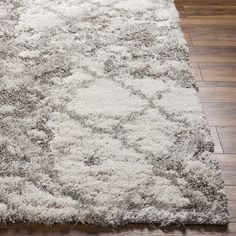 a white rug on top of a wooden floor next to a hard wood flooring