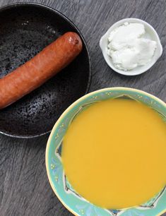 a bowl of soup and a hot dog on a table