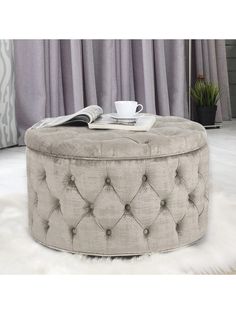 a round ottoman sitting on top of a white rug