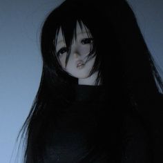 a doll with long black hair wearing a black dress and piercings on her nose