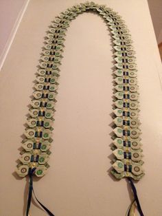 two necklaces made out of dollar bills on a table with scissors and other items