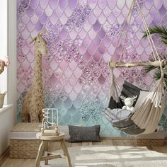 a room with a hammock chair, rug and wallpaper that has mermaid scales on it