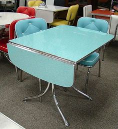 a table with four chairs around it in a room filled with other tables and chairs