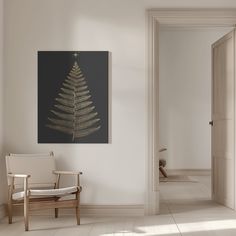 a white room with a chair and a christmas tree on the wall in front of it