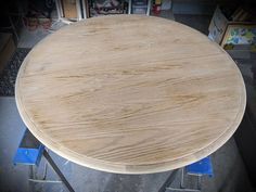 a round wooden table sitting on top of blue dollys