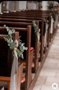 the pews are decorated with greenery and ribbons